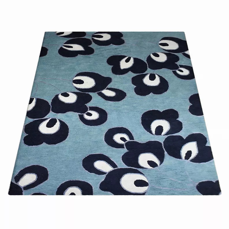 Floral area rug with blue field and dark navy flower clusters with white details