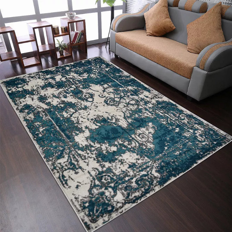 Abstract area rug with teal, blue, and white distressed damask-style design