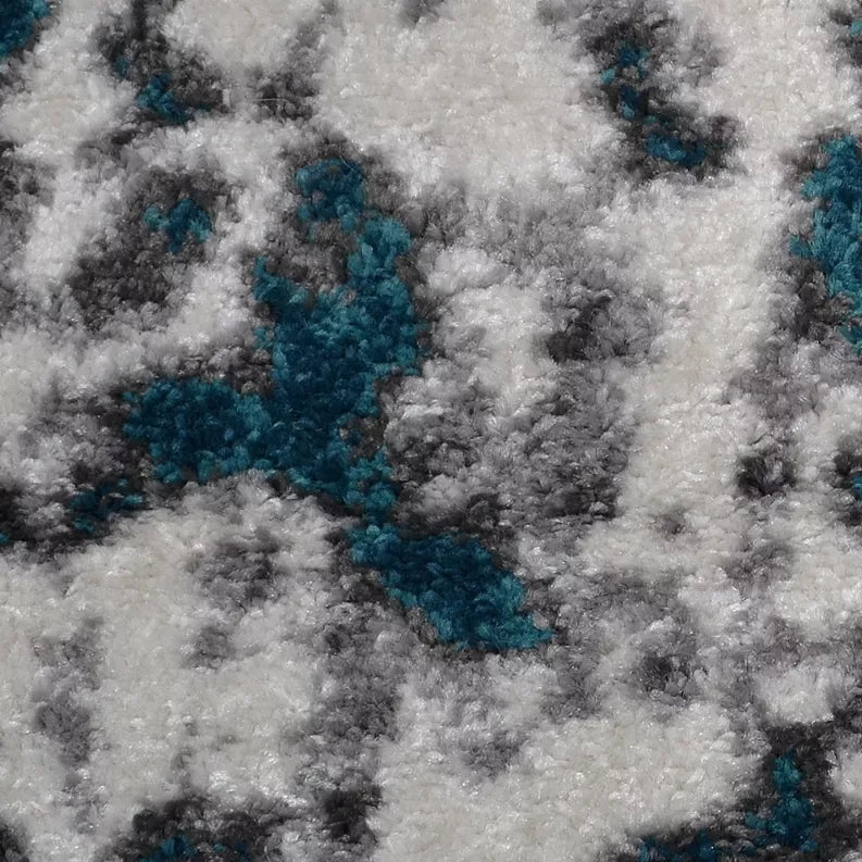 Abstract area rug close-up texture with teal accents over white speckled pile