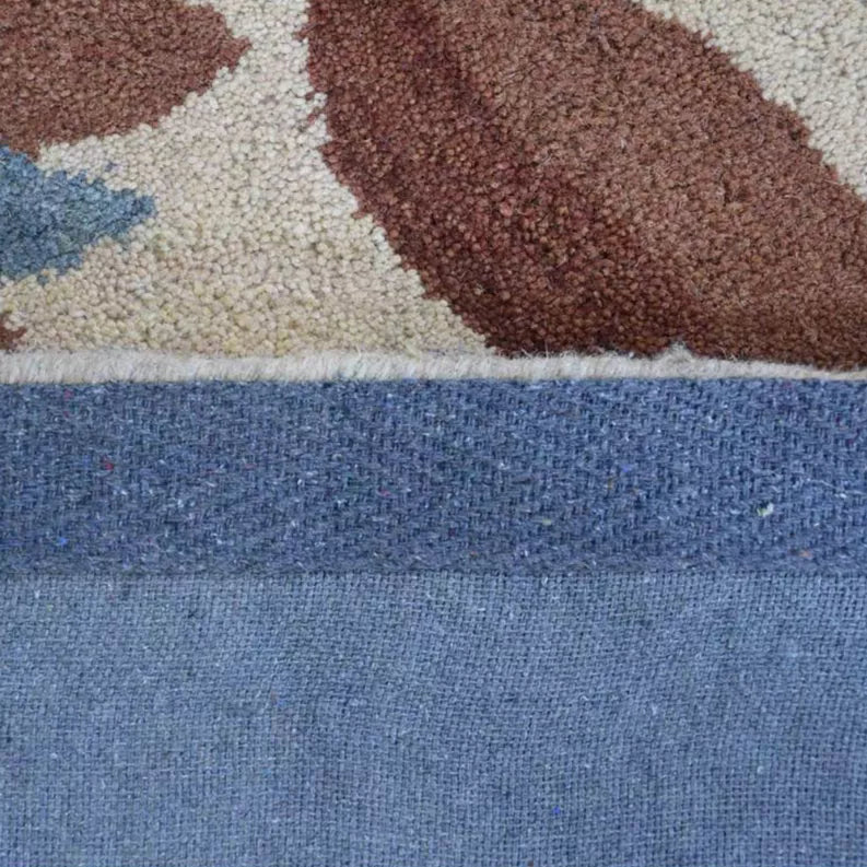 Hand-tufted shag area rug edge close-up showing brown pile and blue border