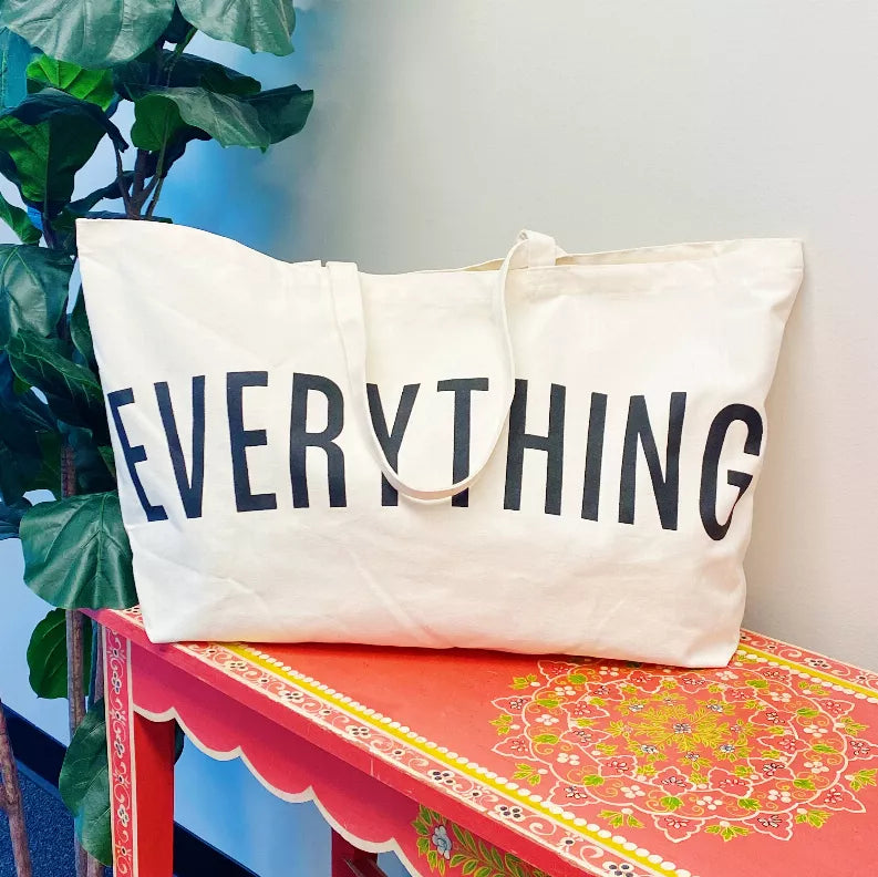Cream canvas tote with "EVERYTHING" in dark letters and short top handles.