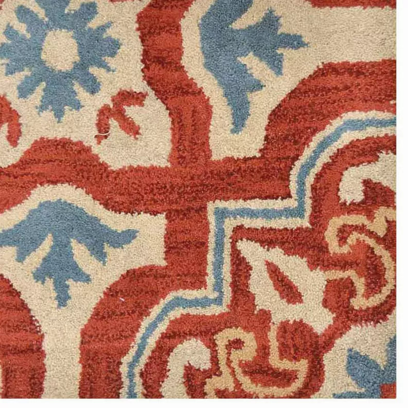 Close-up floral rug section with red background, blue motifs, and cream outlines