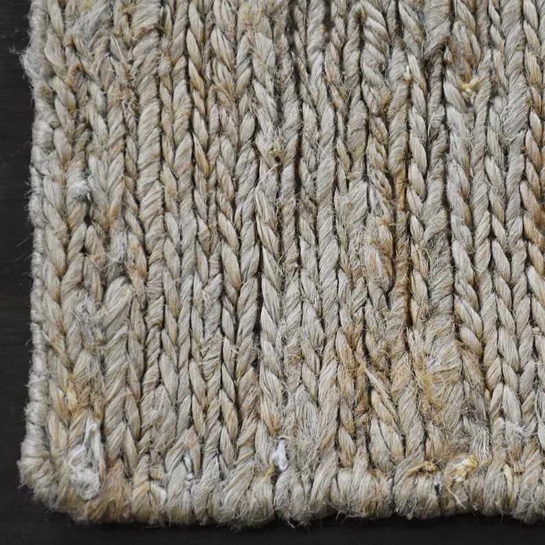 Close-up of jute area rug weave with thick braided strands in beige and gray