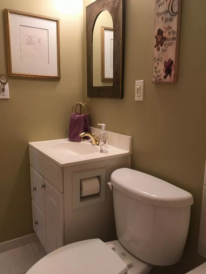 Recessed solid wood toilet paper holder mounted in bathroom wall with a white roll