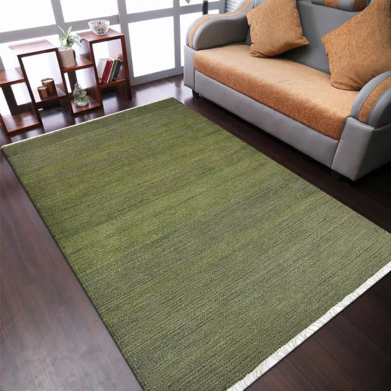Olive green flat-weave wool kilim area rug with white border fringe on corners