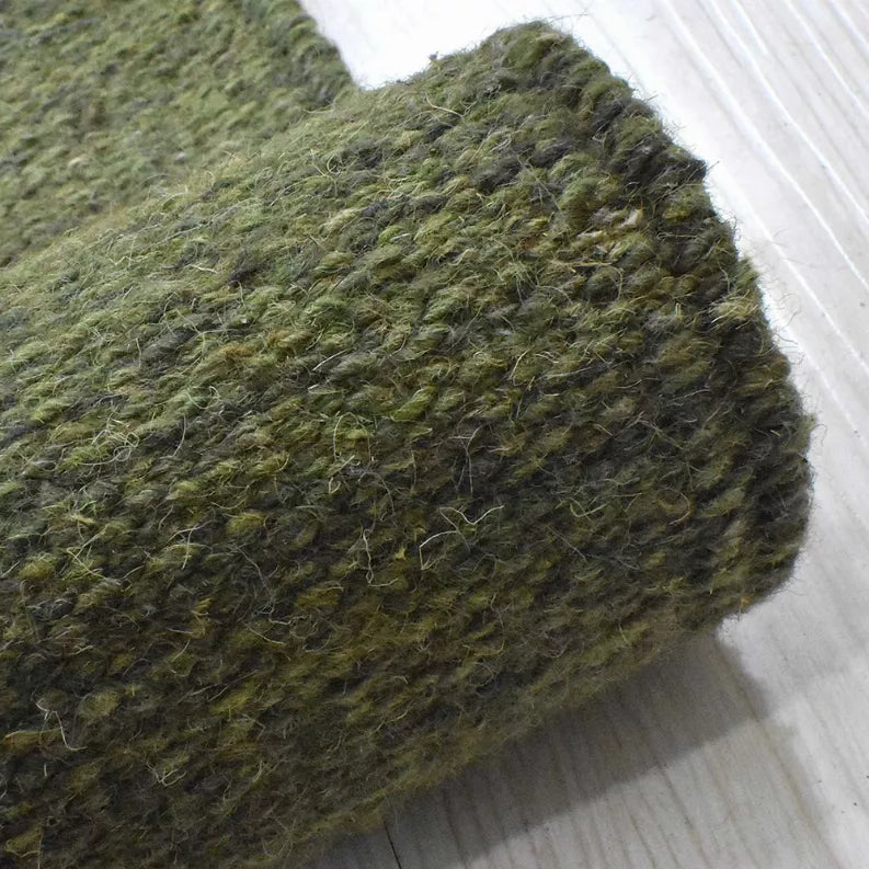 Olive green hand-woven wool kilim rug corner detail with soft flat texture