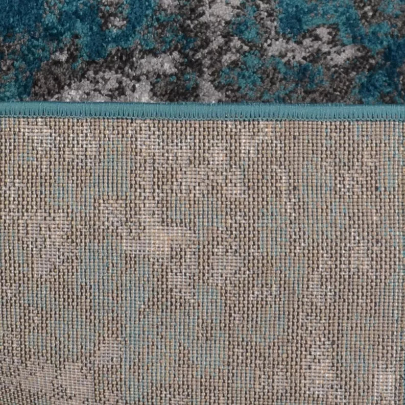 Rug edge detail showing textured beige ground with teal border stripe