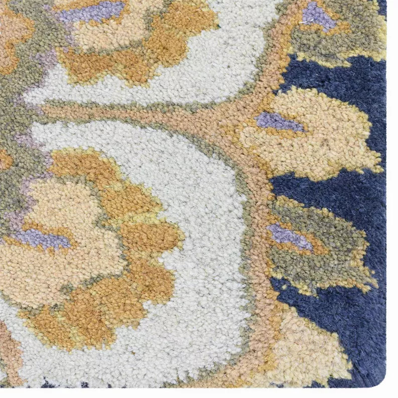 Hand-tufted wool area rug with floral medallion pattern in navy, cream, and gold