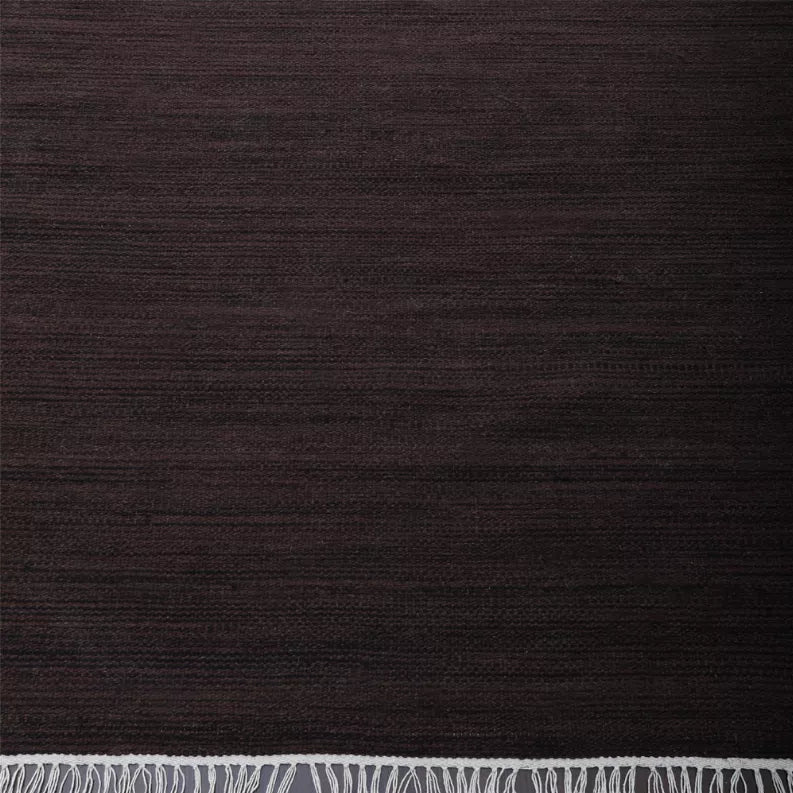 Dark brown flat weave rug surface with tight woven texture and no pattern.