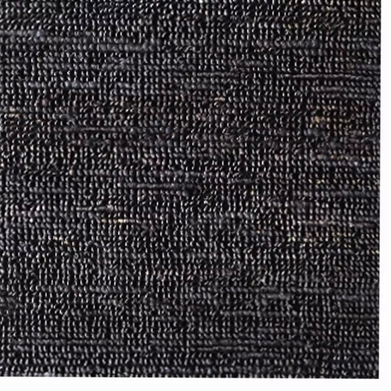 Close-up of charcoal hand-woven jute rug texture with tight woven surface