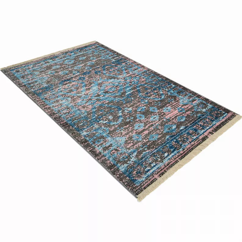 Machine-woven area rug with blue medallion design, pink accents, dark border; cream fringe.