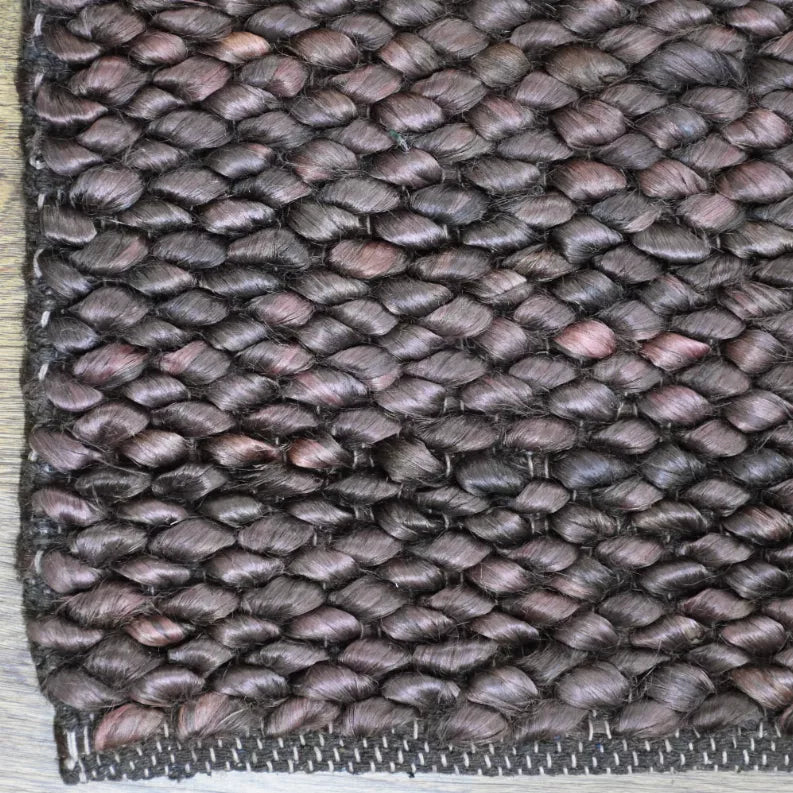 Hand-woven jute area rug, dark gray solid with braided texture and flat woven edge