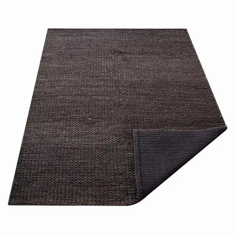 Hand-woven jute area rug, dark charcoal brown, solid weave with folded corner edge