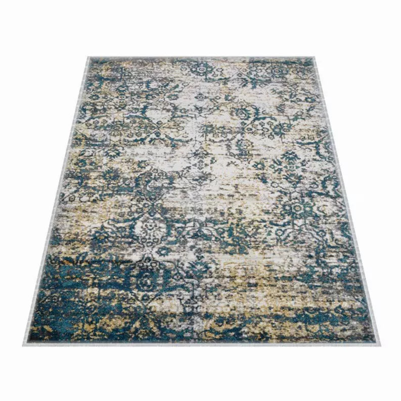 Full view abstract area rug with ornate distressed pattern in blue, teal, and beige