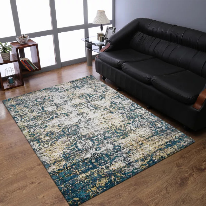 Abstract area rug with ornate blue medallions and beige highlights under living room setup