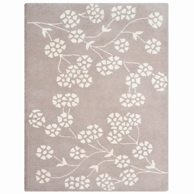 Hand tufted wool area rug with white floral and vine pattern on light taupe