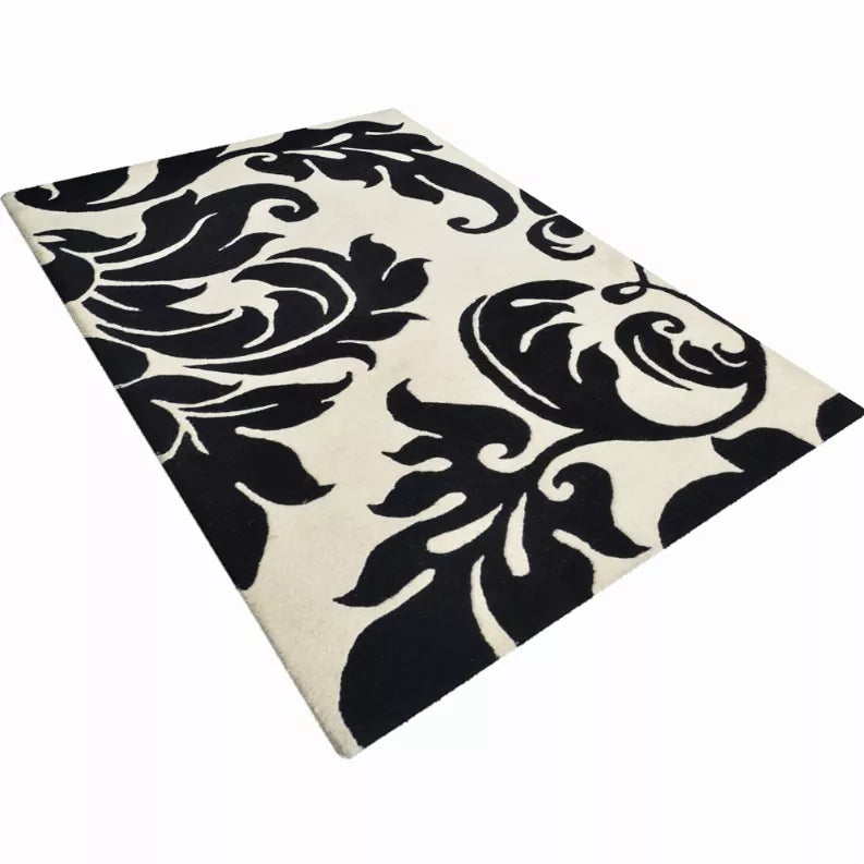 Hand-tufted wool rug with black and cream floral pattern, full corner view