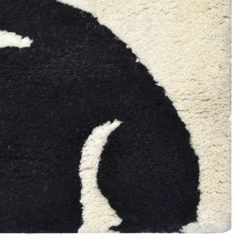 Hand-tufted wool rug, black and cream floral pattern, textured close-up