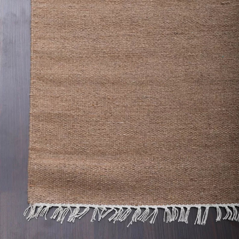 Tan wool flatweave kilim area rug texture with short fringe trim on edge