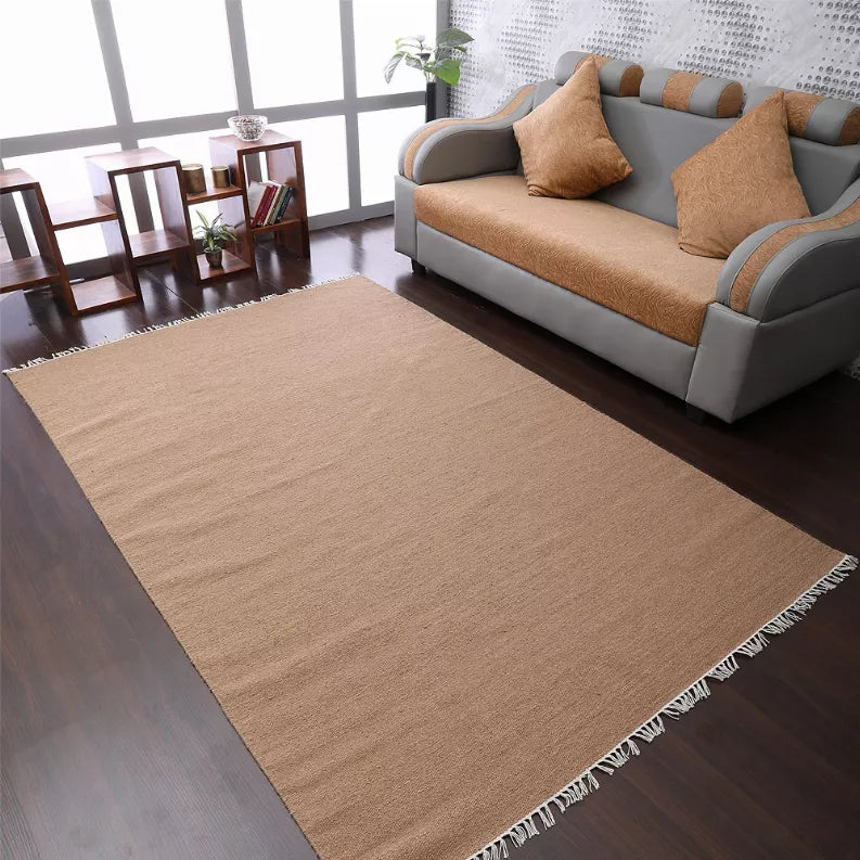 Tan solid flatweave Kilim wool area rug with white fringed corners