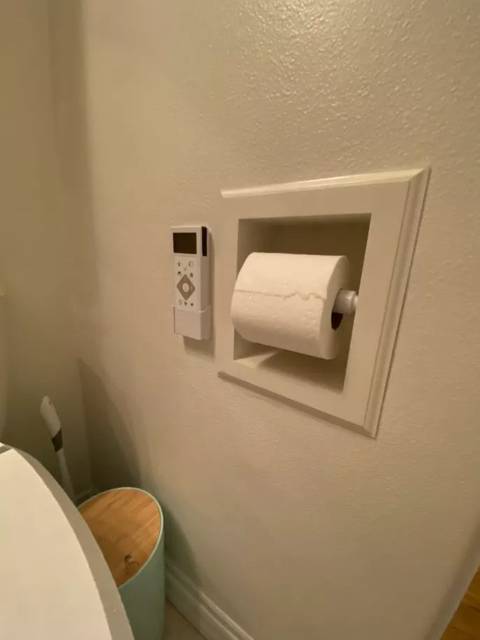 Recessed wood toilet paper holder with white frame holding a toilet roll