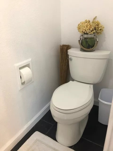 Recessed wood toilet paper holder with a white roll mounted in the wall