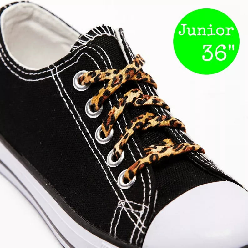 Black sneaker close-up with leopard-print shoelaces and silver eyelets