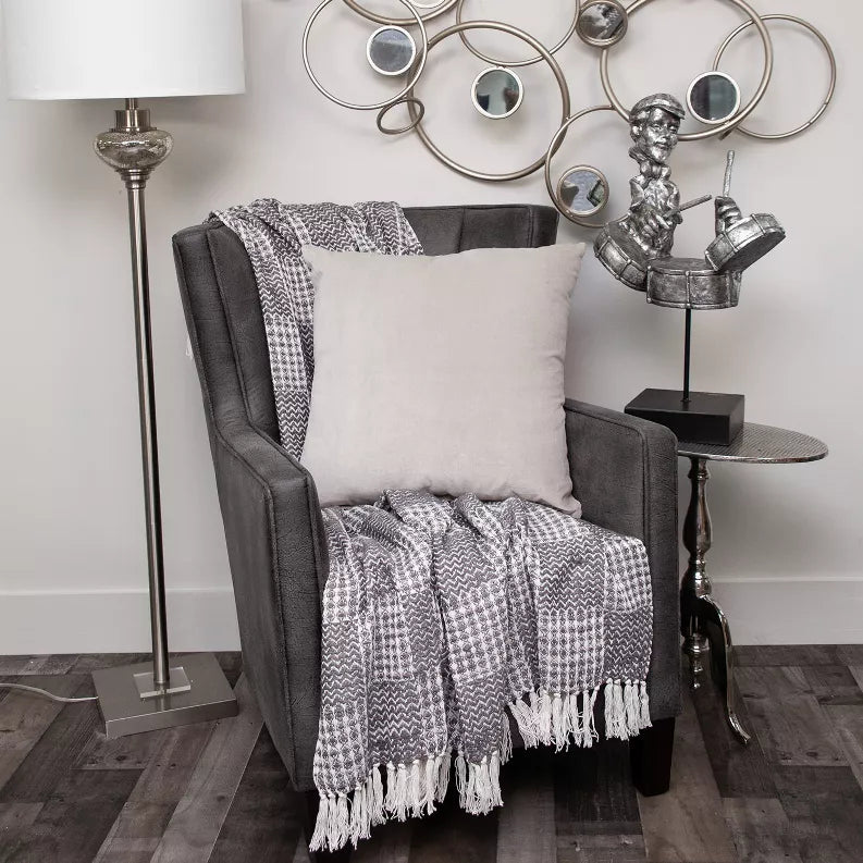 Gray solid throw pillow with smooth fabric, shown on an upholstered chair arm