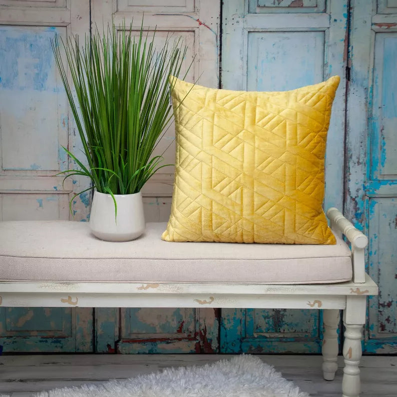 Mustard yellow quilted throw pillow with geometric pattern front and corner seams