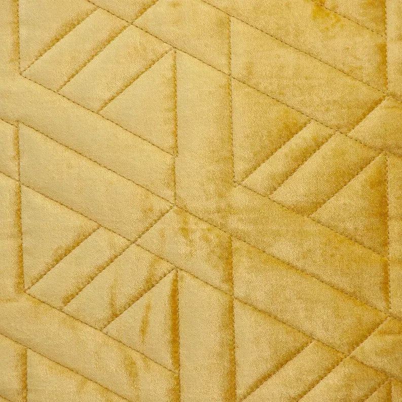 Close-up of mustard yellow quilted throw pillow with diamond geometric stitching