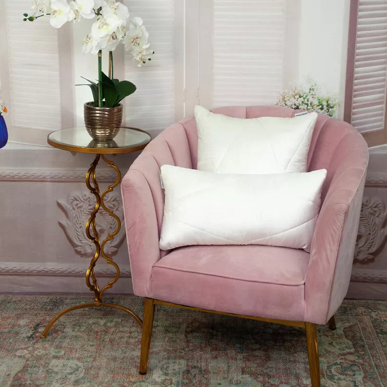 White quilted throw pillow on a pink upholstered chair, square stitched face