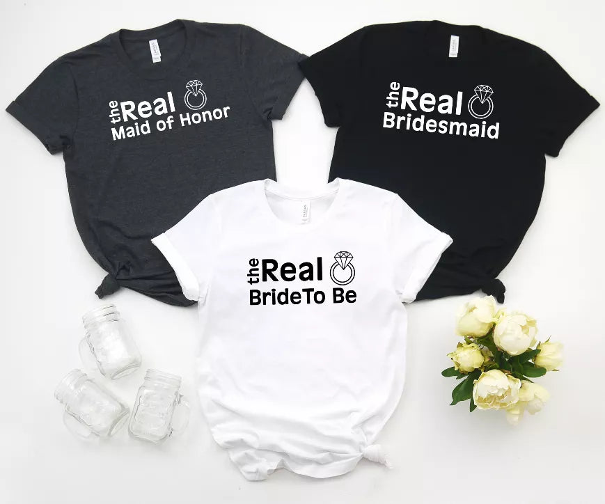 Three bachelorette T-shirts: black 'Real Maid of Honor' & 'Real Bridesmaid', white 'Real Bride To Be'.