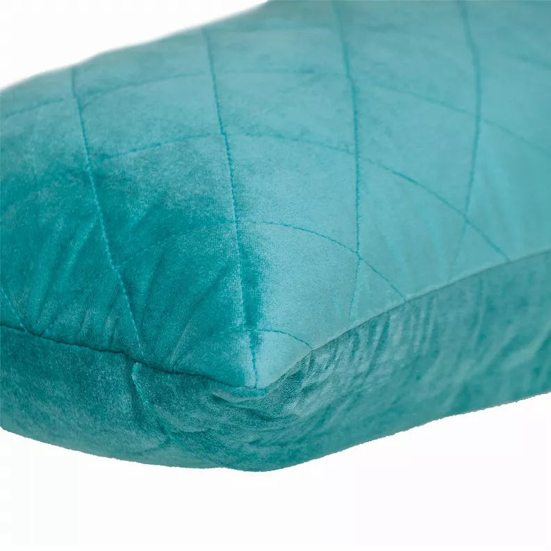 Turquoise quilted throw pillow with diamond stitching and a piped edge corner close-up.