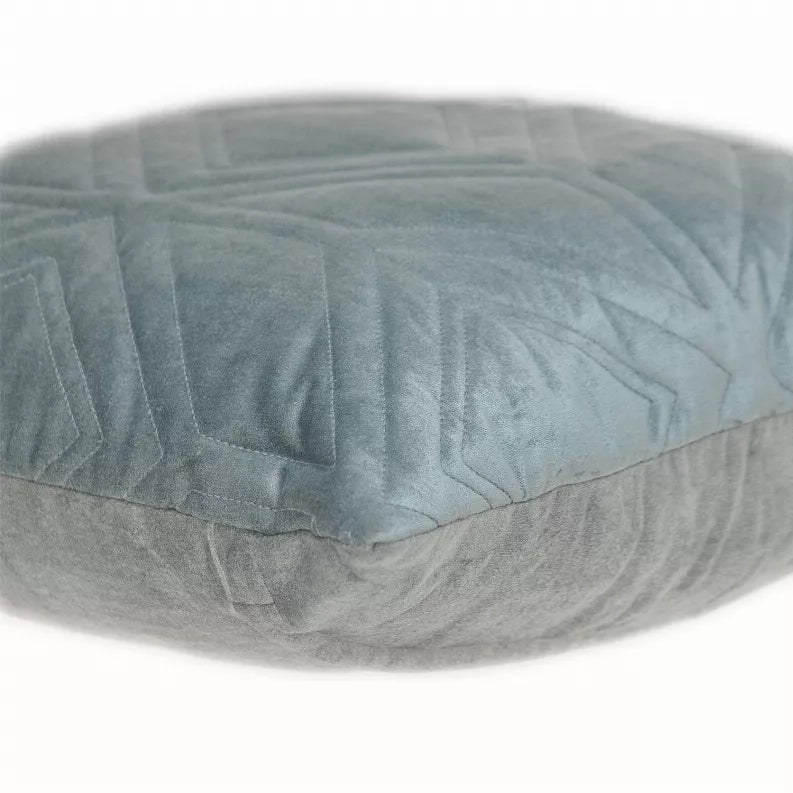 Close-up of blue-gray quilted throw pillow with chevron and channel stitching texture
