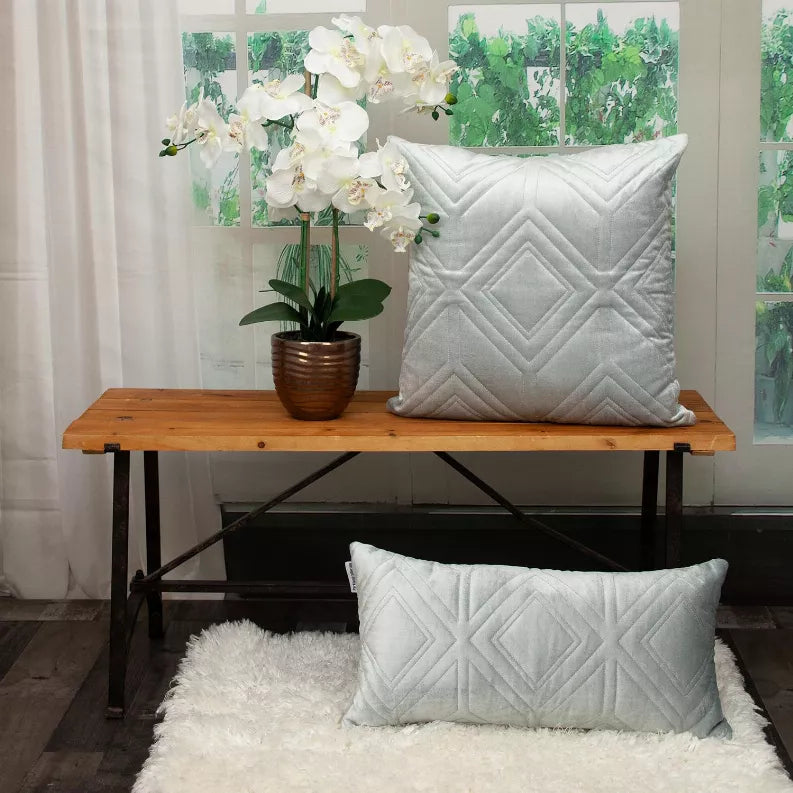 Square white quilted throw pillow with repeating diamond-and-chevron stitch design