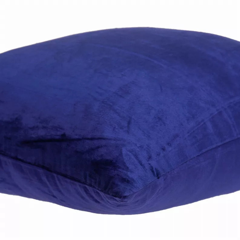 Royal blue throw pillow side close-up with creases and velvet-like texture.