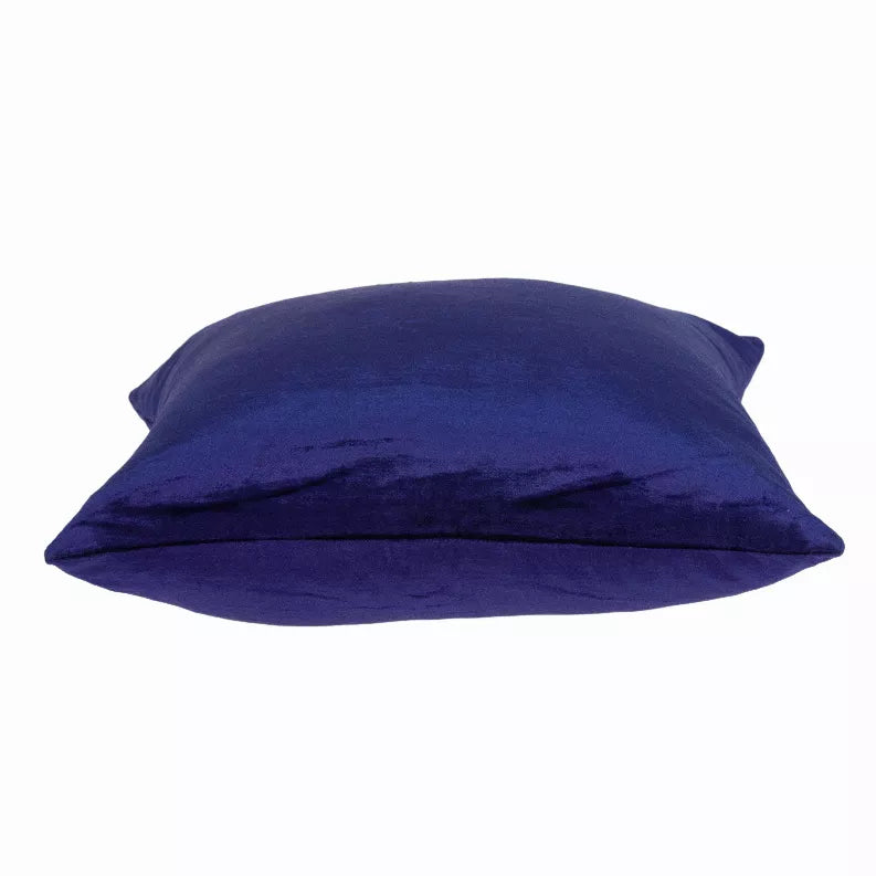 Royal blue solid throw pillow lying down showing top edge and plush filling.