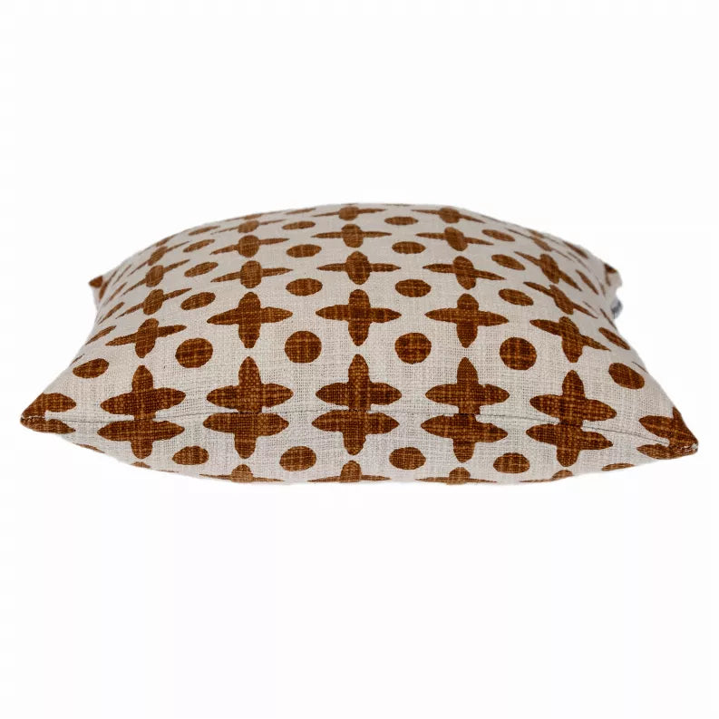 Square decorative pillow with brown geometric cross and dot pattern on cream fabric