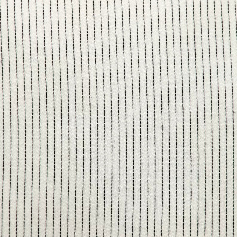 Close-up of light cream pillow fabric with thin vertical dark pinstripes