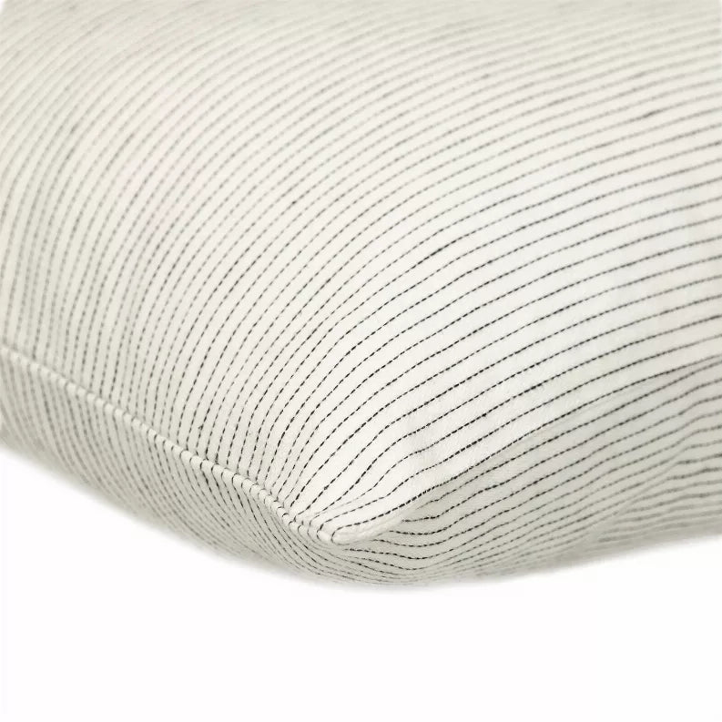 Square throw pillow corner with light cream fabric and thin vertical dark stripes