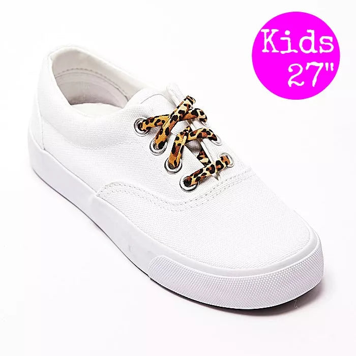 White sneaker close-up with leopard-print shoelaces and metal lace eyelets