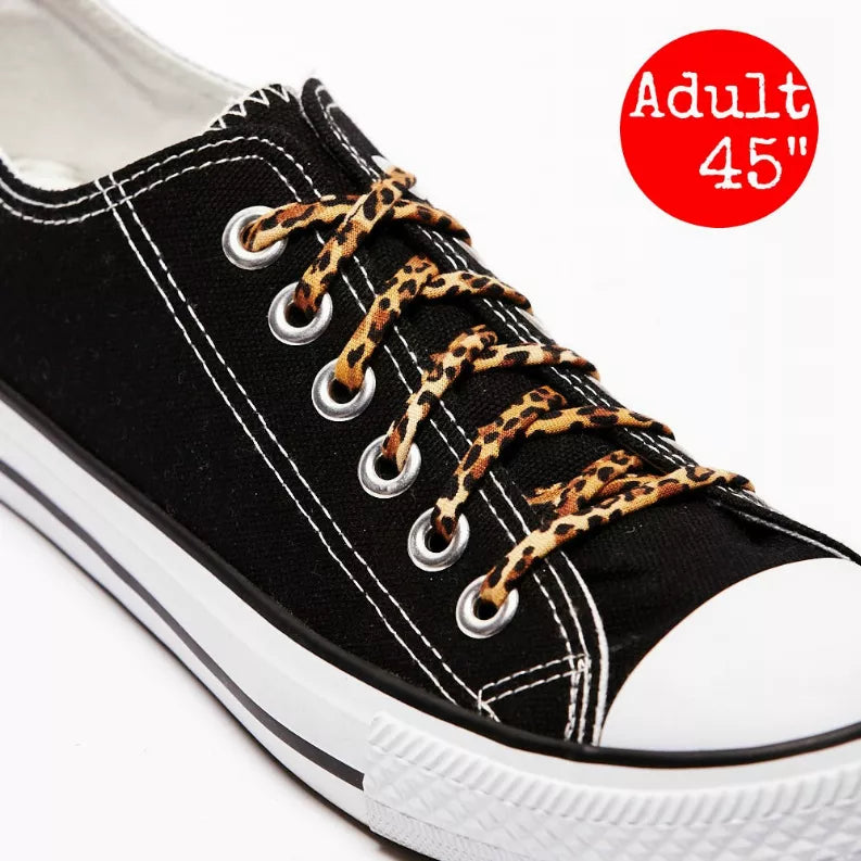 Animal-print shoelaces on black sneakers with leopard-pattern laces and metal eyelets