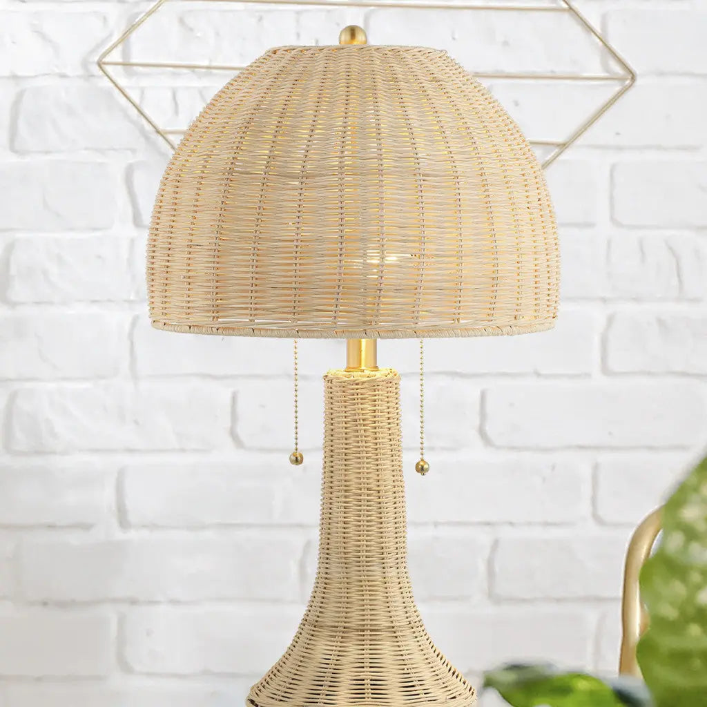 Natural rattan table lamp with gold accents and a round woven shade, perfect for boho decor.