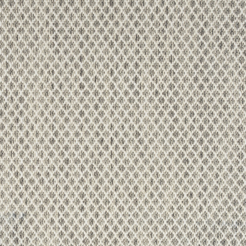 Close-up of ivory rug showing repeating diamond lattice texture with gray-silver accents