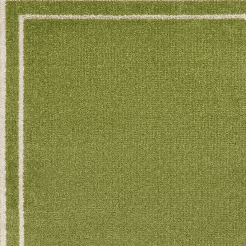 Green runner rug surface with textured pile and ivory border edging along the side.