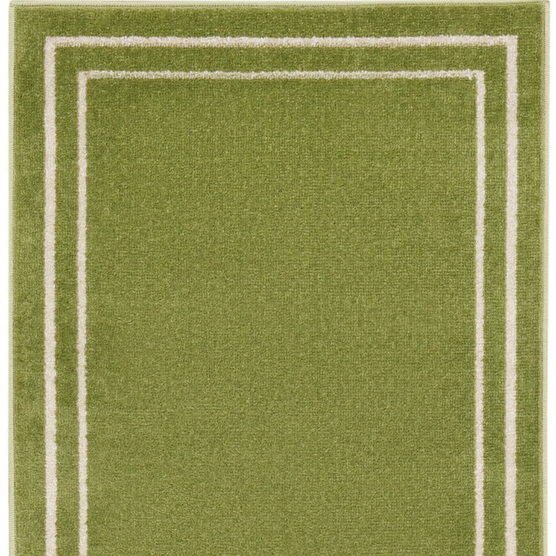 Green runner rug with layered ivory rectangular border stripes and textured pile.