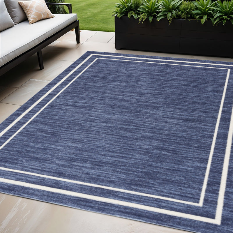 Navy area rug with ivory double-line border and subtle flatweave texture