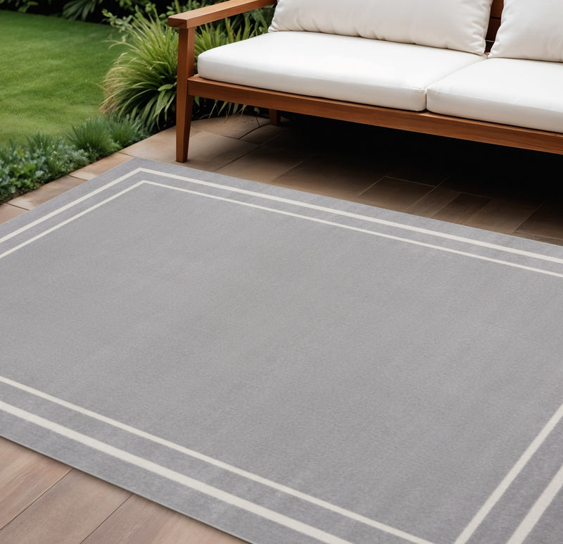 Indoor/outdoor area rug with grey field and wide ivory stripe border.