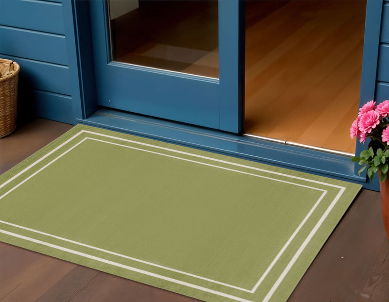 Green area rug with double ivory frame lines in a room setting