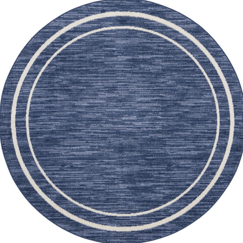 Round navy blue rug with two ivory concentric ring stripes, textured fabric surface.